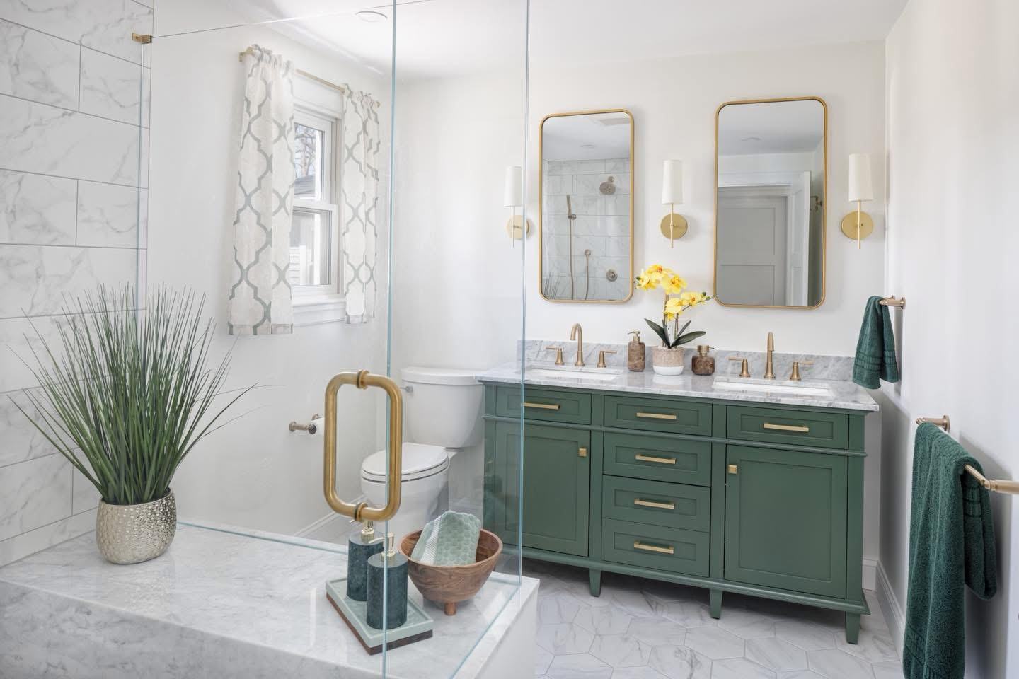 Finished bathroom remodel with green vanity and brass fixtures, plumbing by Ferguson Plumbing Design