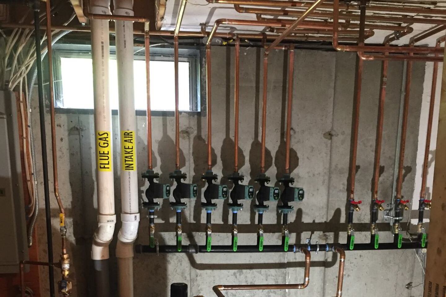 Six-zone copper manifold with zone circulators on a condensing boiler system, installed by Ferguson Plumbing Design